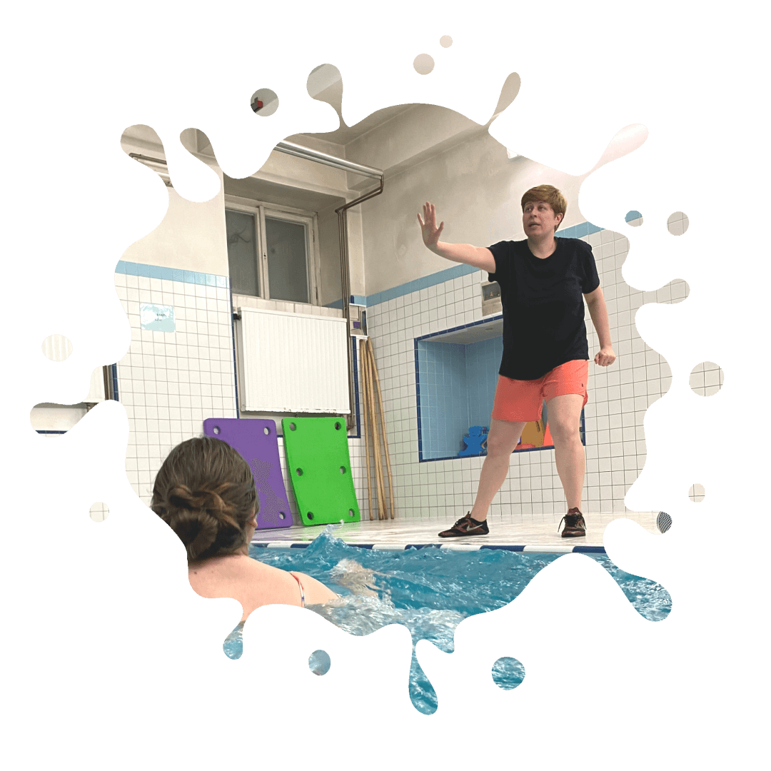 A woman is standing in an indoor swimming pool.