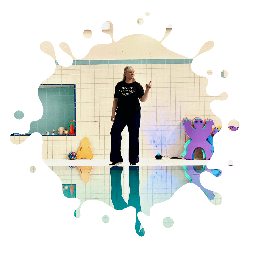 A woman standing in a pool with splashes of water.